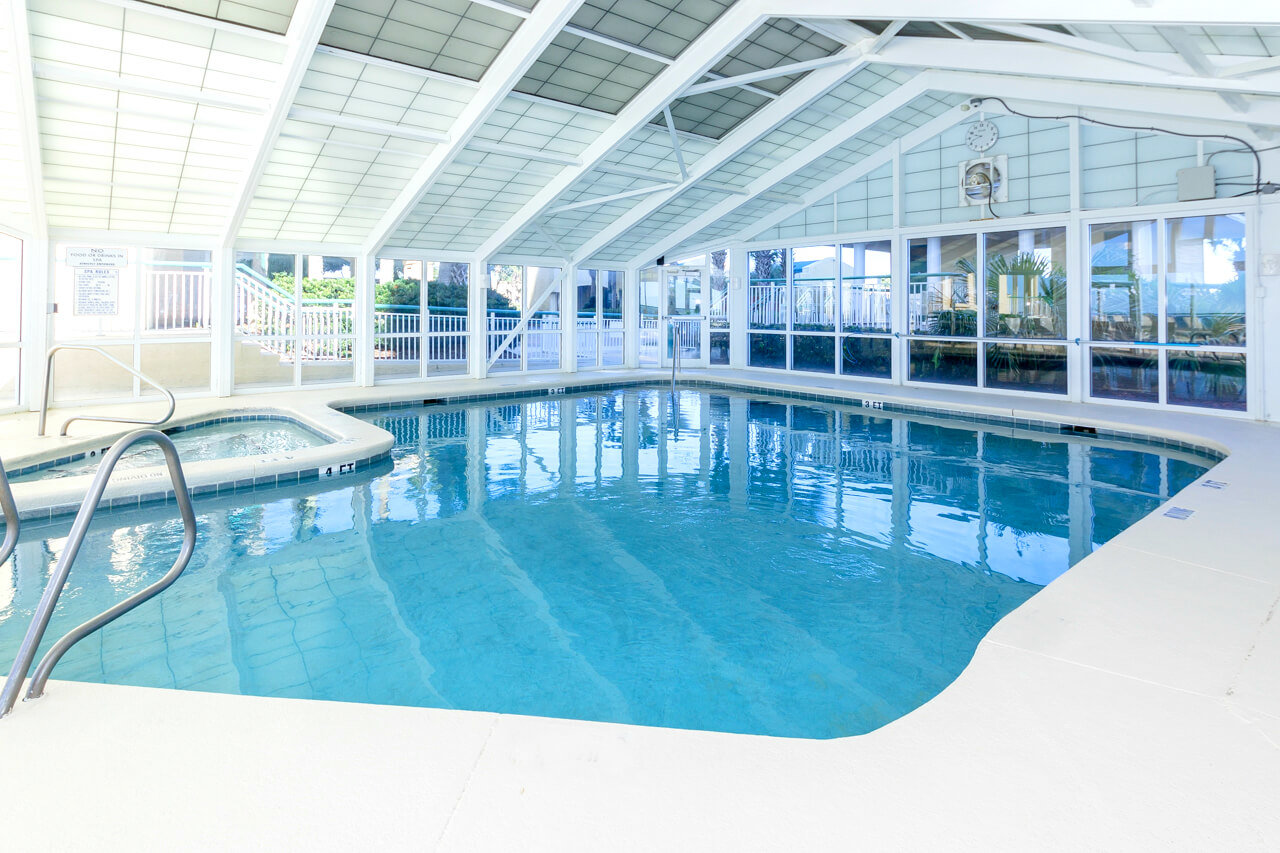 Beach Colony Resort indoor pool area white walls and floors with crystal blue water